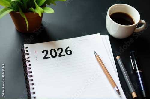 A person journaling with a cup of coffee and the year 2026 written on their notebook..New Year 2026.