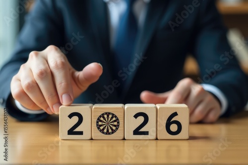 A businessman in a suit plays with wooden blocks, concept of creativity and innovation..New Year 2026.