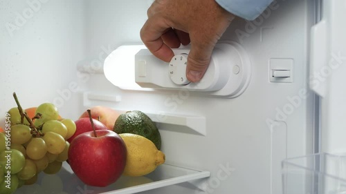 Man Hand Open the Kitchen Fridge Door and Set the Thermostat. Making the Fridge Temperature Control for Optimum Function.