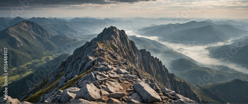 Lone Hiker Standing on Rugged Rocky Summit Overlooking an Endless Misty Valley for Adventure Tourism Commercials, Outdoor Lifestyle Branding, and Motivational Nature Campaigns
