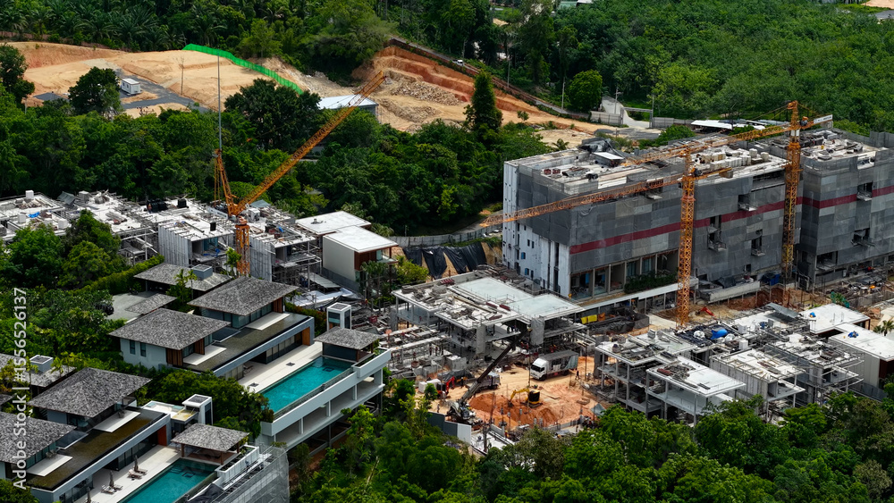 Fototapeta premium Bangtao area, investment expensive real estate on Phuket island. Construction of new luxury villas and condominiums and finished objects, drone view. Construction site, equipment and people working.