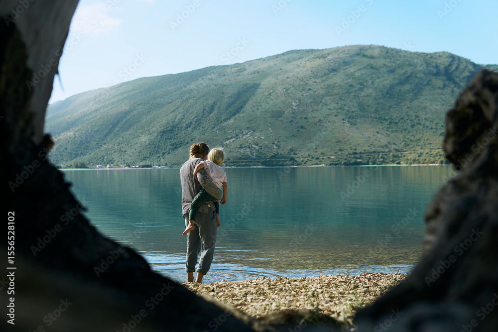 Family bonding experience by the serene lake in the Alps during a sunny day with majestic mountain backdrop Family bonding experience by the serene lake in the Alps during a sunny day with majestic mountain backdrop