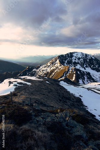 Majestic mountain landscape in the Alps showcasing snow-capped peaks and rolling terrain at dusk