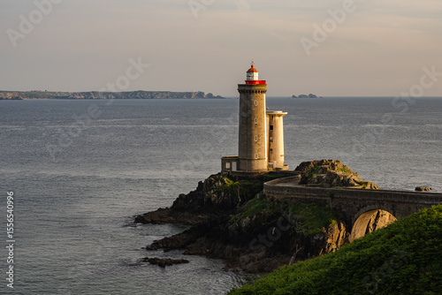 Canvas Print View of the Petit Minou lighthouse near Brest, Brittany, France, illuminated by warm sunset light on a rocky headland above the Atlantic Ocean