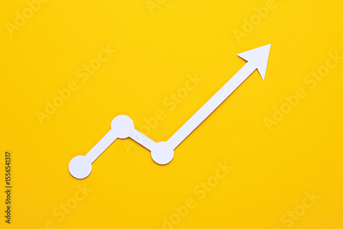 Conceptual Paper Arrow Graph on Yellow Background Illustrating Business Growth and Success with Upward Trend and Positive Direction for Financial Performance and Market Share