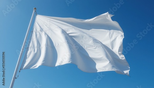 A white flag of surrender waving against a bright blue sky.