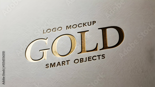 Close up of a gold logo mockup with smart objects on a white surface in a slightly angled view