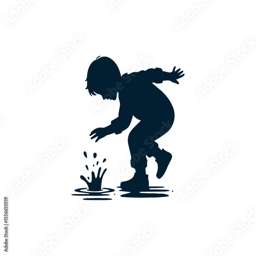 A playful boy splashing in a puddle