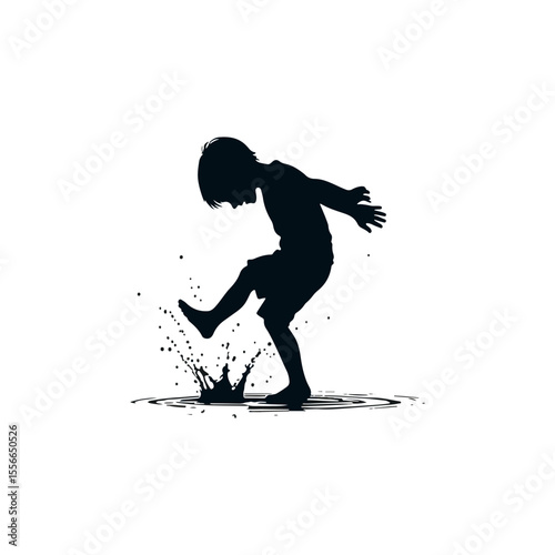 A playful boy splashing in a puddle