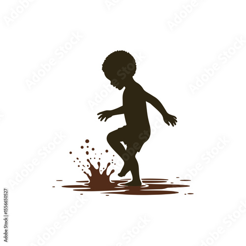 A playful boy splashing in a puddle
