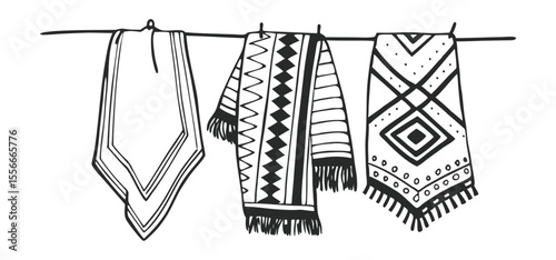 Vector illustration of three patterned ponchos hanging on a clothesline in black and white depicting tribal designs