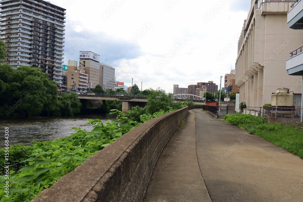 Fototapeta premium June 28, 2025, Morioka, Iwate Prefecture, Japan.View of the Kitakami River and downtown area.