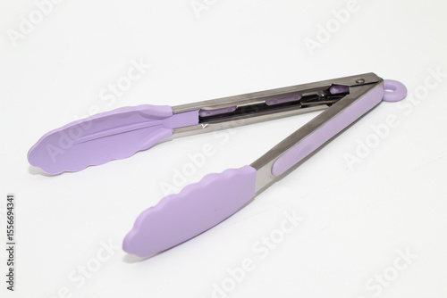 A pair of kitchen tongs with purple silicone tips and stainless steel handles, resting on a clean white surface.