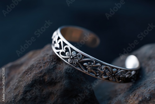 Elegant silver bracelet with intricate patterns on dark textured background