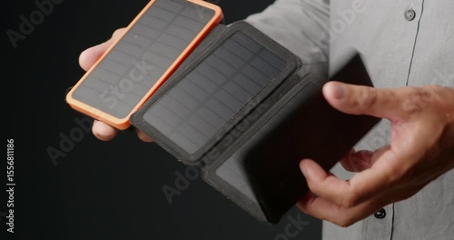 Portable solar chargers with battery power bank showcased in hands. 