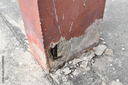 concrete column with exposed rusted rebar and cracked surface