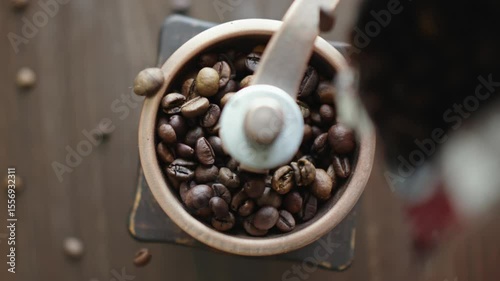 Grinding of aromatic coffee beans with a manual coffee grinder. Smooth rotation of the camera. Top view
