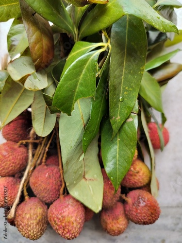 Litchi, also known as lychee or lichee, is a tropical fruit known for its sweet, aromatic flavor and juicy flesh Close display.