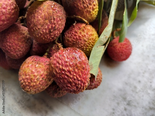 Litchi, also known as lychee or lichee, is a tropical fruit known for its sweet, aromatic flavor and juicy flesh Close display.
