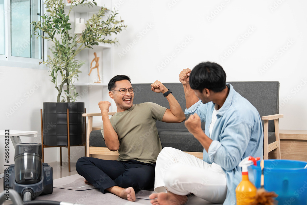 Obraz premium Two joyful men Celebrating Cleaning Success: Happy LGBTQIA Couple