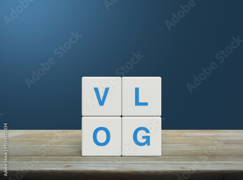 Vlog letter on white block cubes on wooden table over light blue wall, Vlog video marketing concept