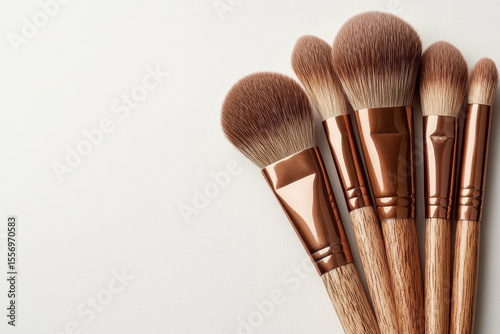 Set of makeup brushes with wooden handles and soft bristles is arranged on white background, showcasing elegance and functionality