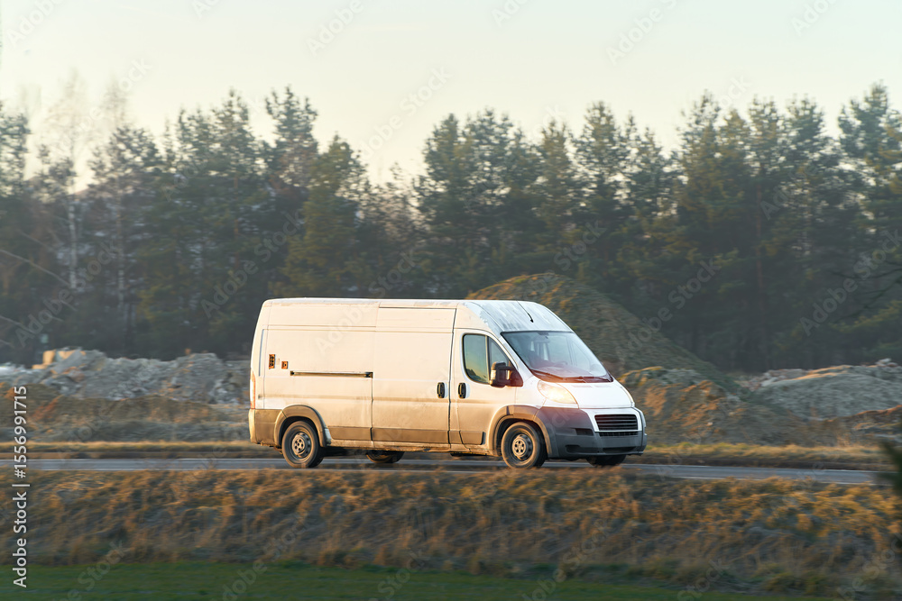 Fototapeta premium White cargo van driving on open road