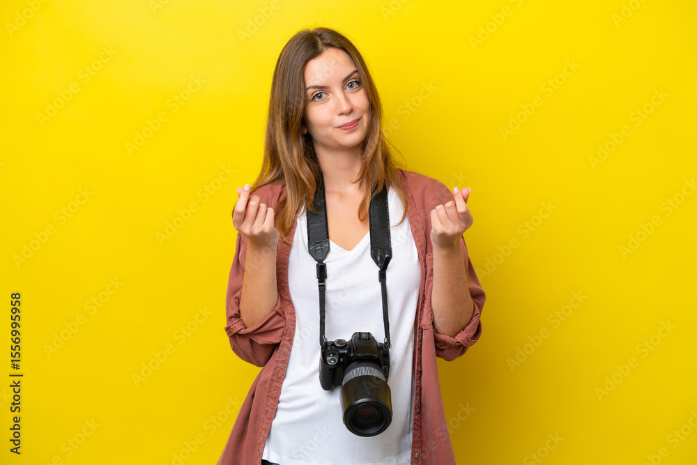 Fototapeta premium Young photographer caucasian woman isolated on yellow background making money gesture