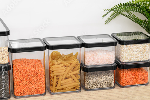 Plastic hermetically sealed containers for loose products stand on a shelf in the kitchen