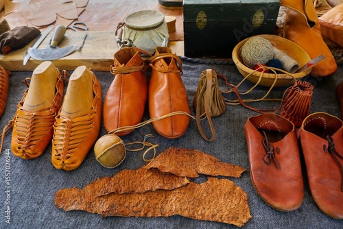 Traditional Leather Footwear at Historical Craft Fair. Authentic Medieval Boots, Pouches, and Crafts from Reenactment Market. Selective focus.