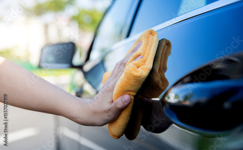 Woman hand cleaning car with a cloth