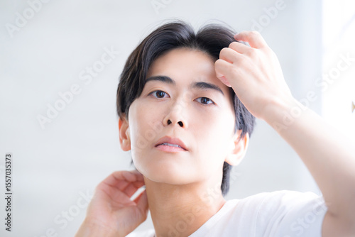 Wallpaper Mural 黒髪を触る透明感のある男性　クローズアップ でヘアケアのイメージ　真剣で真面目な表情 Torontodigital.ca