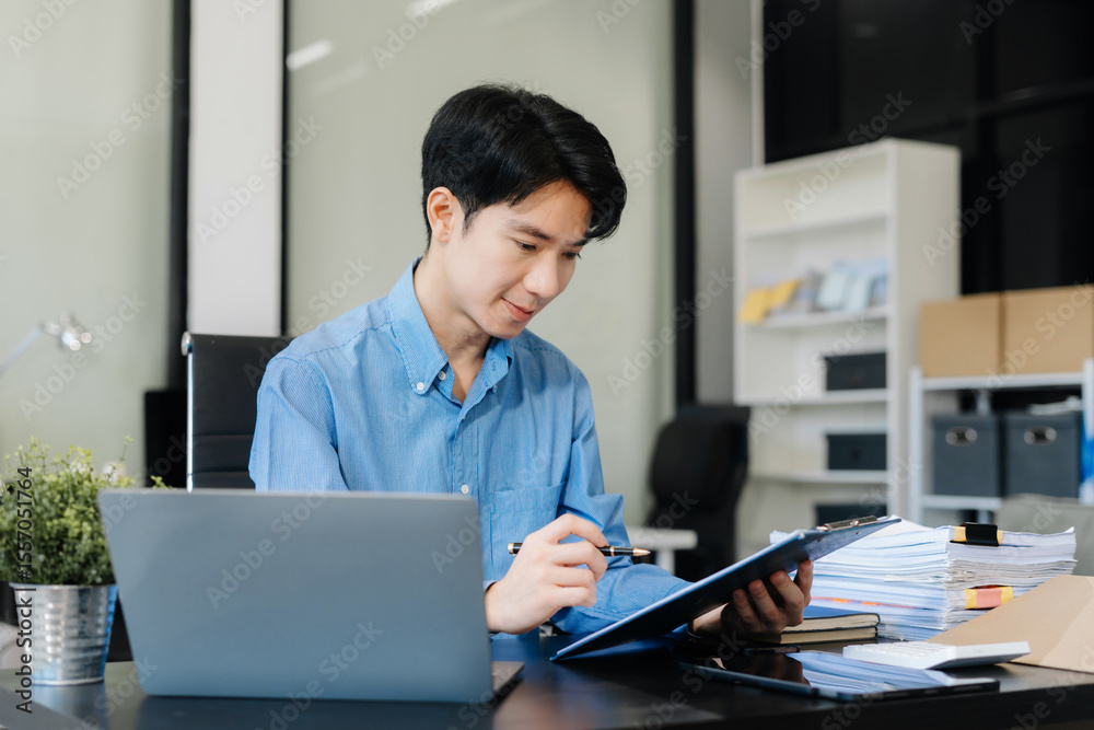 Fototapeta premium Business man working at office with laptop and documents on his desk, financial adviser analyzing data.