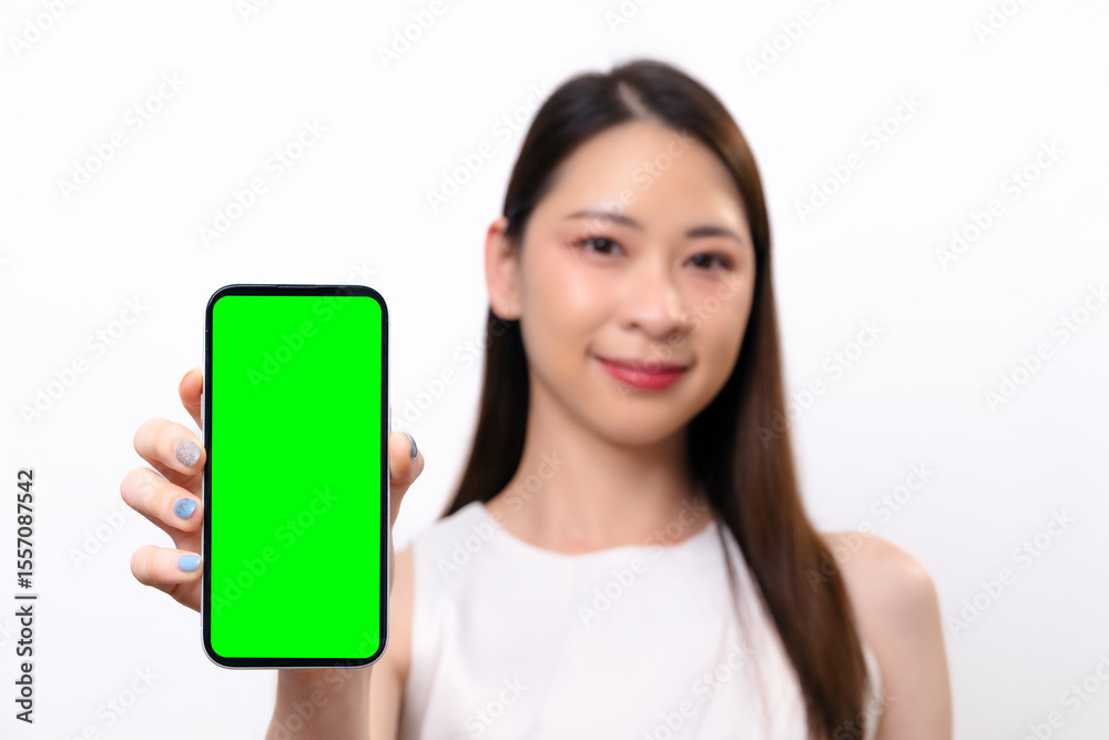 A beautiful Asian businesswoman shows a blank screen of mobile phone. She smiles at the camera A beautiful Asian businesswoman shows a blank screen of mobile phone. She smiles at the camera