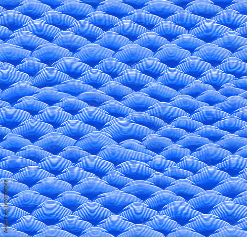Textured blue wave pattern resembling fish scales on a light background