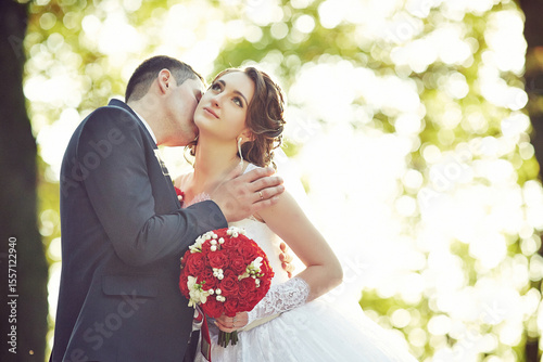 A bride and groom are kissing each other
