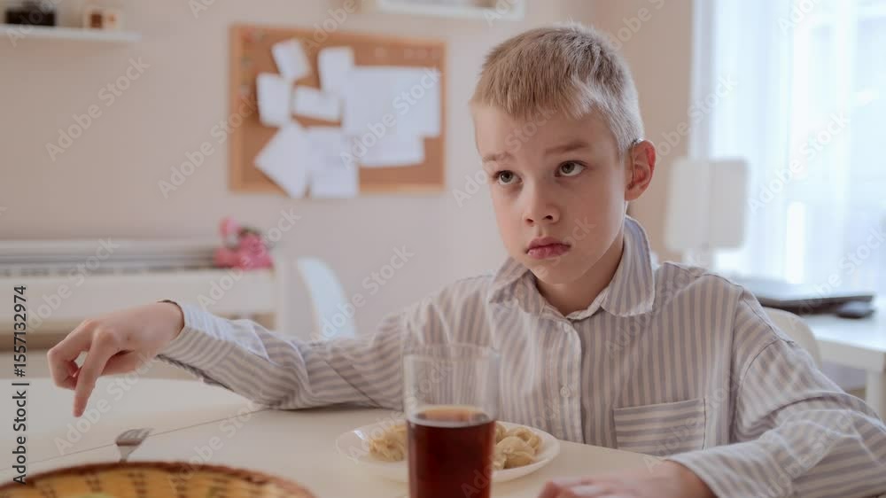 A young boy with a hearing aid enjoys his breakfast at the kitchen table. Natural morning light, cozy atmosphere, and authentic child emotions. Perfect for family, health, and lifestyle content A young boy with a hearing aid enjoys his breakfast at the kitchen table. Natural morning light, cozy atmosphere, and authentic child emotions. Perfect for family, health, and lifestyle content