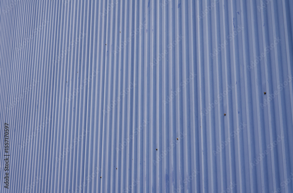 Obraz premium Muted Blue Corrugated Metal Sheet Featuring Vertical Ridges and a Distinct Pattern for Architectural or Abstract Backgrounds