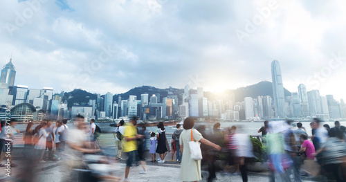 Canvas Print Tourists and citizens enjoying a cloudy day walking on the Hong Kong waterfront,