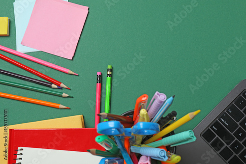 Top view of school supplies, pencils, erasers, paper clips and notebooks, on a green background. ideal image for topics related to education,
