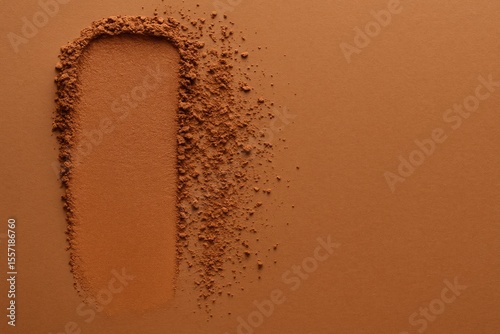 Swatch of warm bronze makeup powder for deep skin tones. Fine, gentle texture. Placeholder space included. Beauty product layout. Overhead perspective