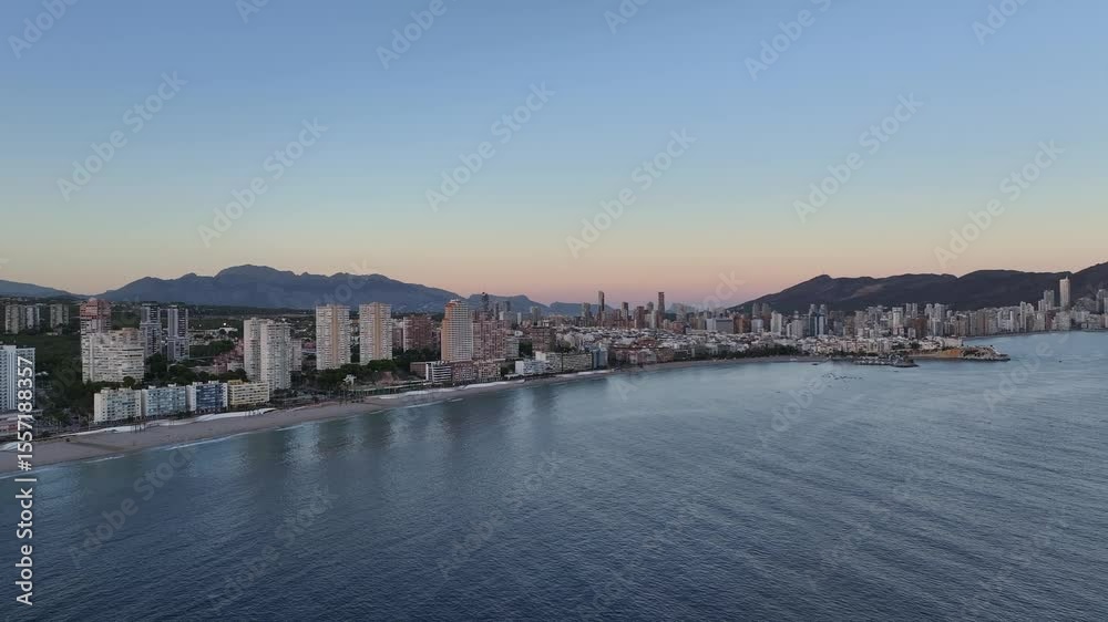 Sunset view over the beach and city of Benidorm, with mountains in the background Sunset view over the beach and city of Benidorm, with mountains in the background