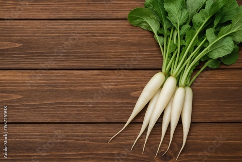Fresh white radishes displayed on a rustic wooden surface for food presentation. photo