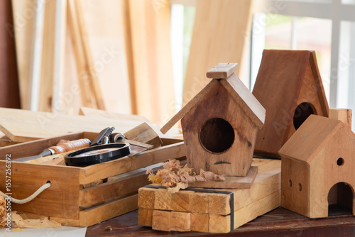Wooden bird house DIY from small piece of leftover wooden after finished furniture, small business or freelance carpenter, Stack of wood dust on background, sawdust in Carpentry Studio shop