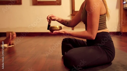 Woman playing tibetan singing bowl in yoga studio