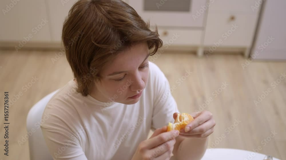 A young woman enjoys a simple meal and drinks tea in her cozy kitchen. Authentic, unposed moment capturing real emotions and the warmth of everyday life. Perfect for lifestyle and food content A young woman enjoys a simple meal and drinks tea in her cozy kitchen. Authentic, unposed moment capturing real emotions and the warmth of everyday life. Perfect for lifestyle and food content