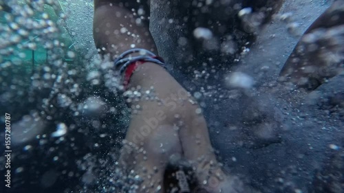 A carefree holidaymaker jumps headfirst into crystal clear sea water in Egypt. Water splashes as a young man in shorts dives headfirst into the blue sea on a summer day. First person shot