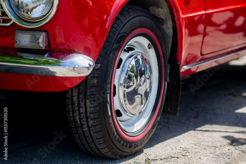 Papier peint close up of red vintage car front wheel with chrome hubcap and whitewall tire de