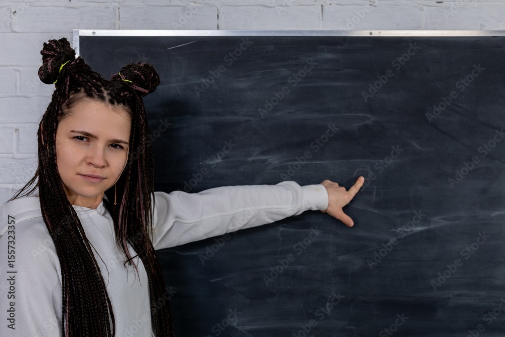Obraz premium An engaged instructor is pointing at a blank chalkboard for various educational purposes