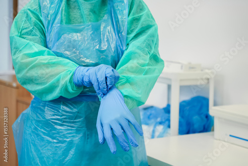 Foto Dedicated medical professional in sterile gown and blue apron meticulously prepa